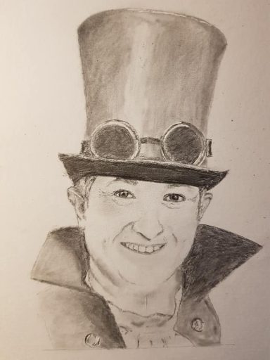 Portrait d'une personne souriante portant un haut-de-forme et des lunettes steampunk.