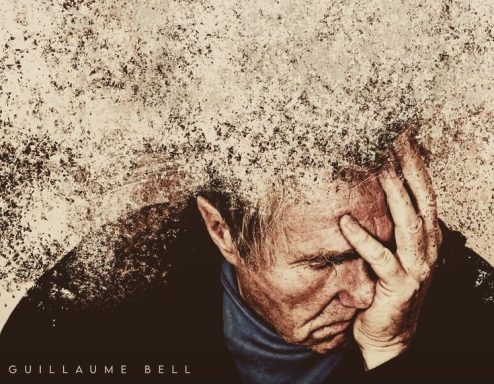 Un homme se tenant la tête, l'air accablé, avec des particules floues autour de lui.