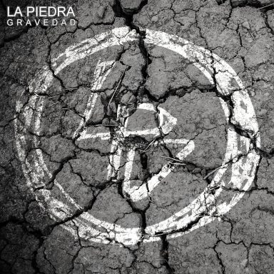 Symbole en blanc sur un sol fissuré, avec le texte "LA PIEDRA GRAVEDAD" en haut.